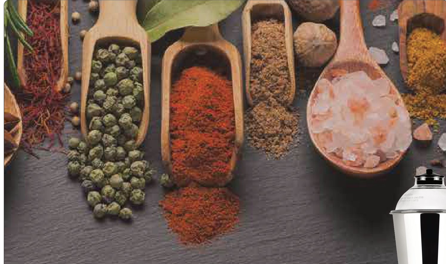 Spices in wooden scoops on slate